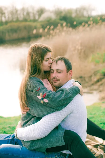 Bir çift uzun boylu genç adam ve uzun sarı saçlı kız arkadaşı nehir kıyısında şehrin dışında yürüyorlar. Duygular ve duygular. Yaşam tarzı. Ülke havası