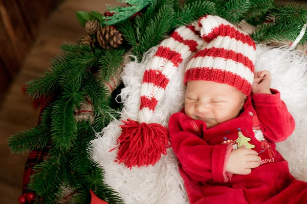 一个穿着红色西服 头戴帽子的可爱的小宝宝睡在圣诞装饰中 圣诞气氛 快乐的童年 — 图库照片