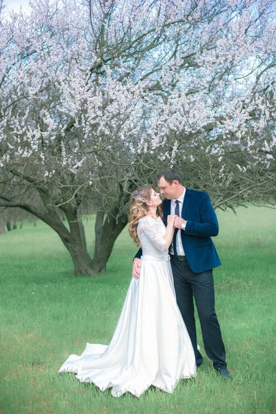 Menyasszony Vőlegény Szőke Hosszú Hajjal Fehér Ruhában Egy Tavaszi Kertben — Stock Fotó