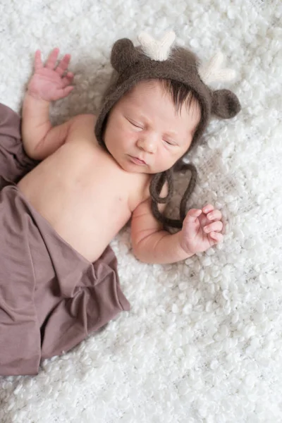 Ein Niedliches Kleines Baby Strickmütze Mit Hirschhörnern Und Brauner Decke — Stockfoto