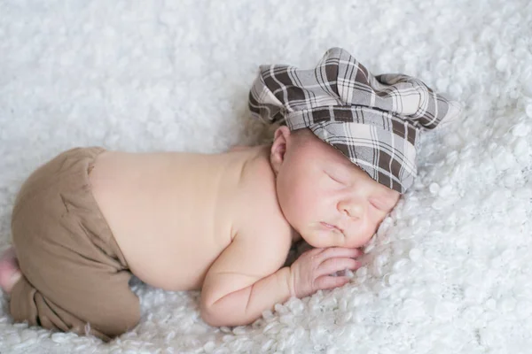 Χαριτωμένο Μωράκι Ένα Καρό Vintage Καπέλο Κοιμάται Ένα Λευκό Κάλυμμα — Φωτογραφία Αρχείου