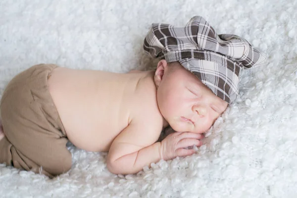 Χαριτωμένο Μωράκι Ένα Καρό Vintage Καπέλο Κοιμάται Ένα Λευκό Κάλυμμα — Φωτογραφία Αρχείου