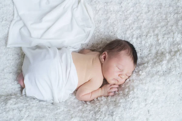 一个穿着白色毯子的可爱的小宝宝睡在家里的白色花束床罩上 健康和母性 — 图库照片