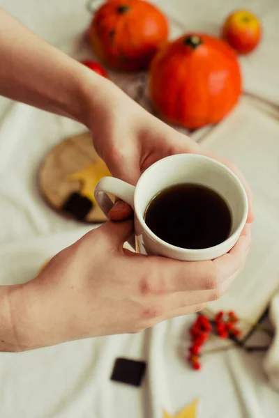 カボチャやリンゴや黄色の葉の秋の静物を背景にお茶を片手に 秋の気分 — ストック写真