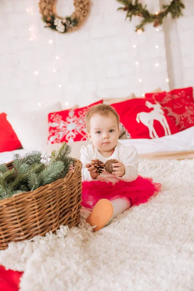 一个一岁以下的小女孩 穿着一件轻飘飘的衣服 躺在一间装饰着圣诞节的房间里的一张大床上 睡在花环和松针的枕头里 圣诞气氛 儿童与圣诞节 — 图库照片