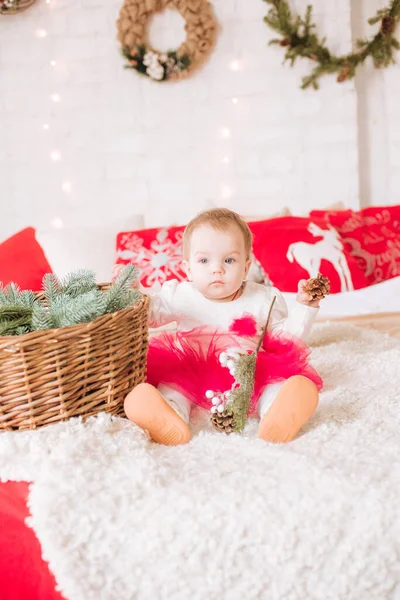 一个一岁以下的小女孩 穿着一件轻飘飘的衣服 躺在一间装饰着圣诞节的房间里的一张大床上 睡在花环和松针的枕头里 圣诞气氛 儿童与圣诞节 — 图库照片