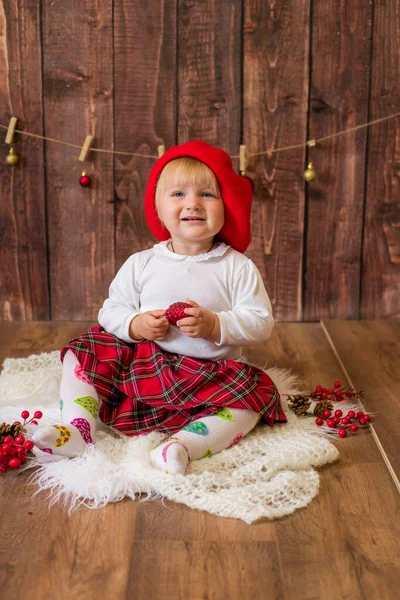 赤いスカートを着た可愛い女の子と クリスマスのために装飾された部屋でコーンとクリスマスのおもちゃで赤いフェルトベレー帽の演劇 クリスマスと子供たち — ストック写真