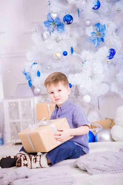 Söt Pojke Blå Skjorta Med Gåva Handen Nära Vit Julgran — Stockfoto