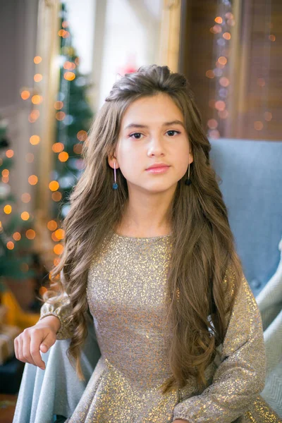 一个可爱的少女 留着长长的卷发 穿着闪亮的裙子 房间装饰着闪亮的花环 准备过圣诞节 圣诞气氛 美与时尚 — 图库照片
