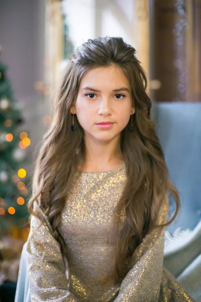 一个可爱的少女 留着长长的卷发 穿着闪亮的裙子 房间装饰着闪亮的花环 准备过圣诞节 圣诞气氛 美与时尚 — 图库照片