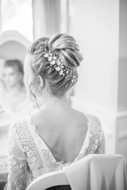 Yatak odasındaki yatak odasının yanında inci ve kristallerle düğün saç stili olan genç ve güzel bir gelin. düğün sabahı