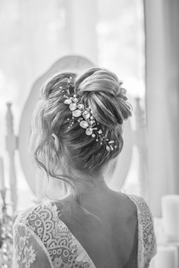 Yatak odasındaki yatak odasının yanında inci ve kristallerle düğün saç stili olan genç ve güzel bir gelin. düğün sabahı