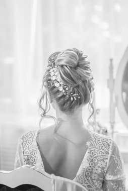 Yatak odasındaki yatak odasının yanında inci ve kristallerle düğün saç stili olan genç ve güzel bir gelin. düğün sabahı