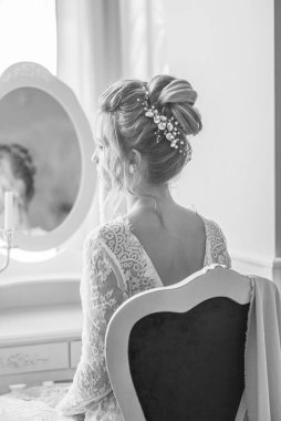 Yatak odasındaki yatak odasının yanında inci ve kristallerle düğün saç stili olan genç ve güzel bir gelin. düğün sabahı