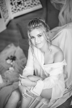 Sabahları düğün saç modeli ve makyajlı, yatak odasında beyaz ipek geceliğiyle genç ve güzel bir gelin. düğün sabahı