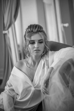 Sabahları düğün saç modeli ve makyajlı, yatak odasında beyaz ipek geceliğiyle genç ve güzel bir gelin. düğün sabahı