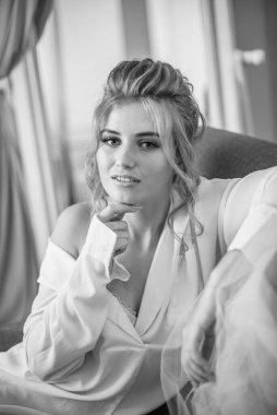 Sabahları düğün saç modeli ve makyajlı, yatak odasında beyaz ipek geceliğiyle genç ve güzel bir gelin. düğün sabahı