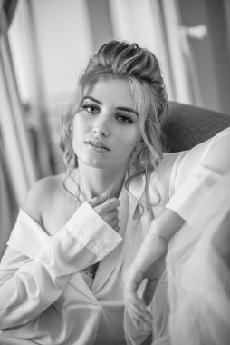 Sabahları düğün saç modeli ve makyajlı, yatak odasında beyaz ipek geceliğiyle genç ve güzel bir gelin. düğün sabahı