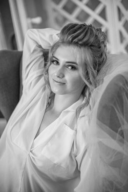 Sabahları düğün saç modeli ve makyajlı, yatak odasında beyaz ipek geceliğiyle genç ve güzel bir gelin. düğün sabahı