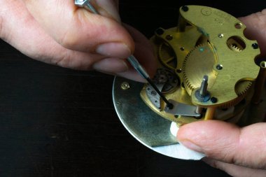 Saatleri aletlerle tamir etmek. Saatçi vidayı söker.