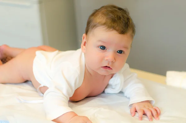 Bebê bonito jaz em sua barriga — Fotografia de Stock