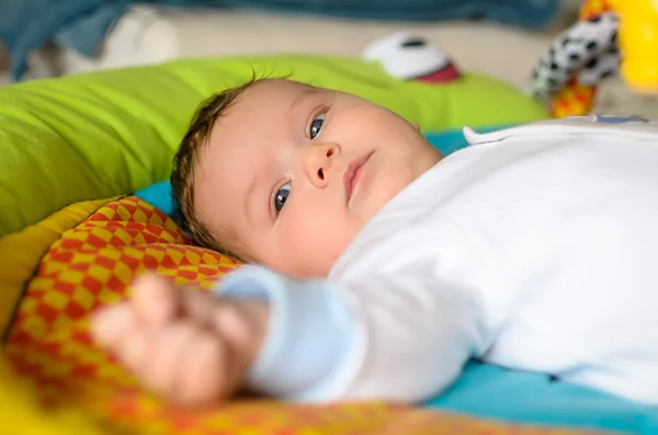 Χαριτωμένο μωρό αγόρι βρίσκεται στο πολύχρωμο χαλί — Φωτογραφία Αρχείου