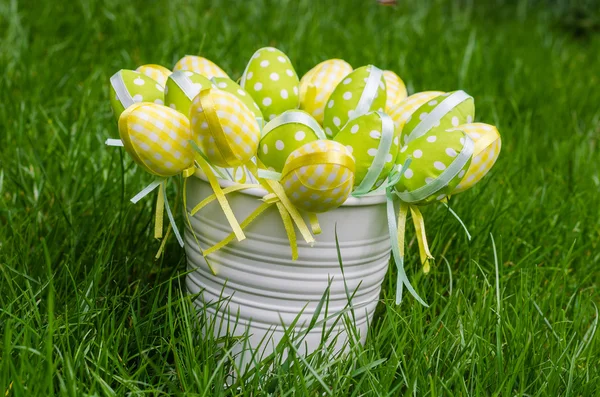 Huevos de Pascua en cubo blanco sobre hierba — Foto de Stock