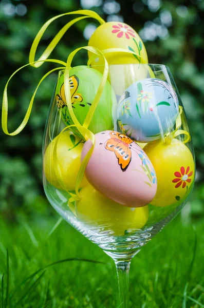 Painted easter eggs in glass on green grass — Stock Fotó