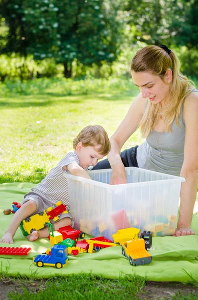 Mignon bébé garçon joue des jouets avec la jeune mère dans le parc — Photo