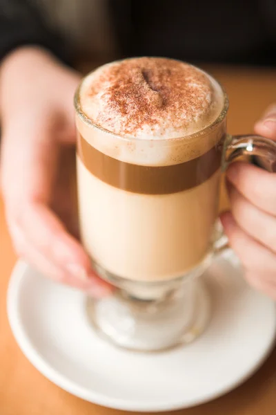 Woman holding hot cafe latte — Stock Photo, Image