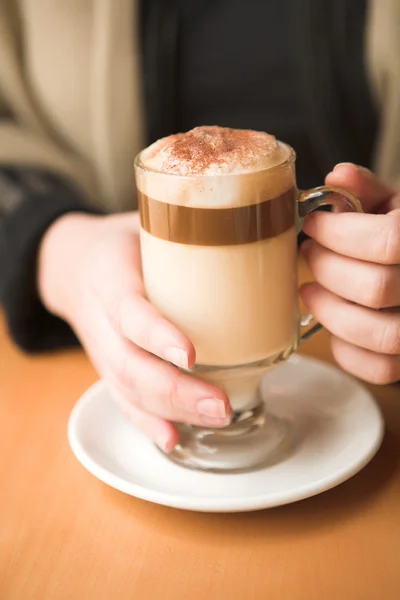 Woman holding hot cafe latte — Stock Photo, Image