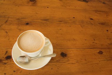 Tahta bir masada bir fincan kahve.