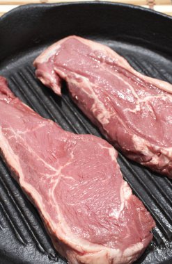 siyah dökme demir tavada hazırlanan çiğ biftek