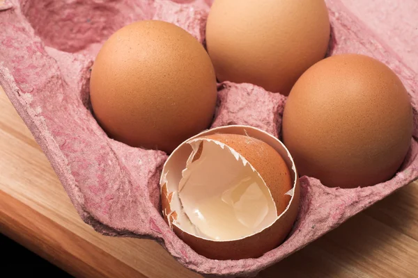 Eggs in an eggholder on a wooden cutting board — Stock Photo, Image