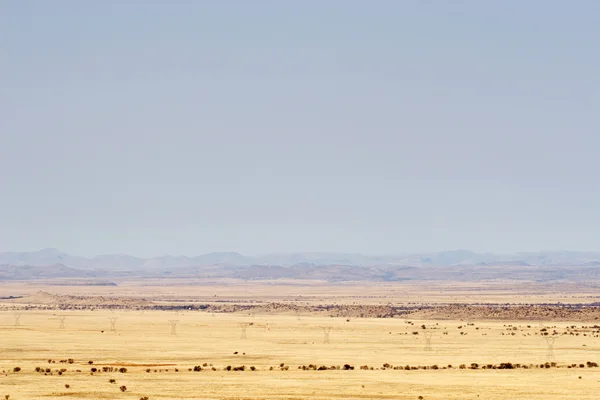 Cielo blu con nuvole drammatiche su un paesaggio desertico — Foto Stock