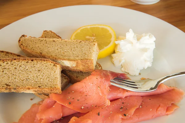Celozrnný chléb s lososem, citron a krém na talíři — Stock fotografie