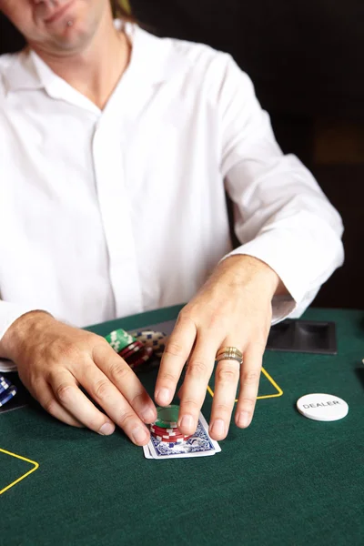 Jogar cartas, fichas e jogadores jogando em torno de uma mesa de poker de feltro verde — Fotografia de Stock