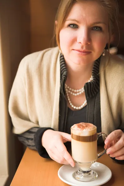 Blonde caucasian adult woman drinking hot cafe latte — Stock Photo, Image