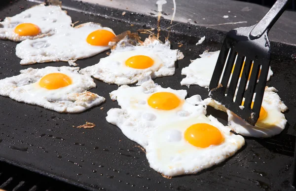 Uova fresche che vengono fritte lato soleggiato su una grande padella — Foto Stock