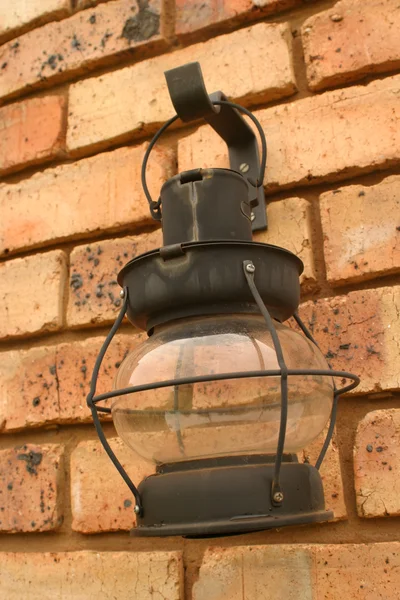 Lanterna di candela nera contro muro di mattoni marrone — Foto Stock