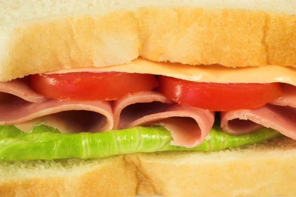 Sanduíche de presunto, queijo, tomate e alface num prato branco — Fotografia de Stock
