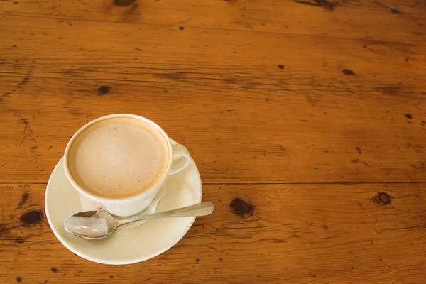 Une tasse de café sur une table en bois — Photo