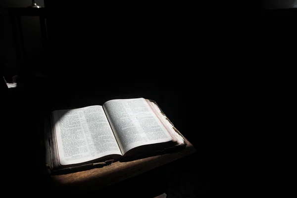 Vieille bible ouverte couchée sur une table en bois — Photo