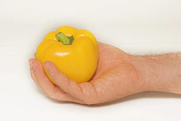 Yellow peppers in a hand on a white background — Stock Photo, Image