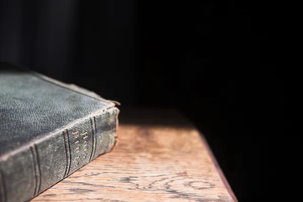 Pelle coperto vecchia bibbia sdraiato su un tavolo di legno — Foto Stock