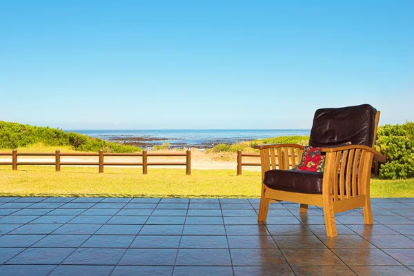 Ein bequemer Ledersessel auf der Terrasse eines Ferienhauses oder einer Residenz am Meer — Stockfoto