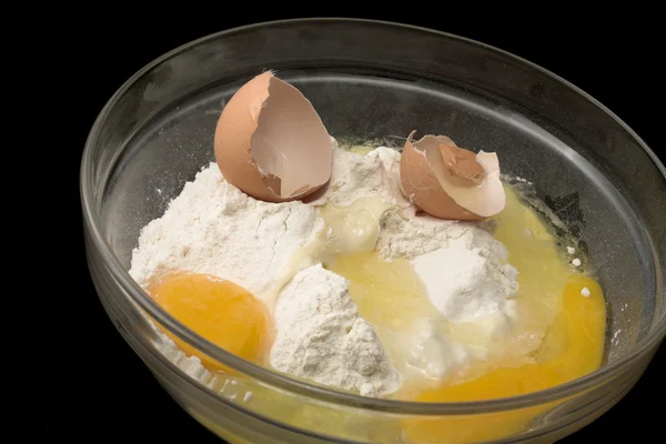 Flour & egg in a glass bowl black background — Stock Photo, Image