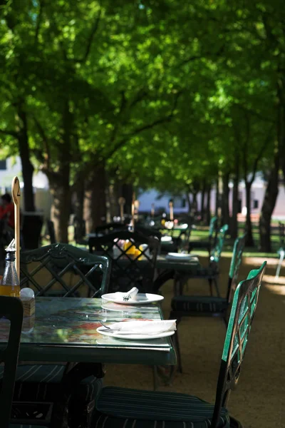 在阳光灿烂的夏天天在与各种空表和开放席位的户外餐厅 — 图库照片