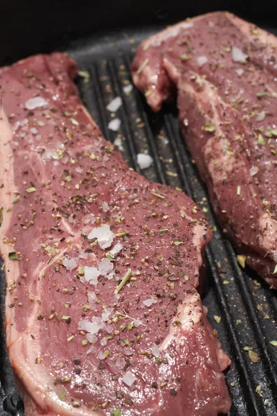 Egy fekete öntöttvas serpenyőben, hogy kész nyers steak — Stock Fotó