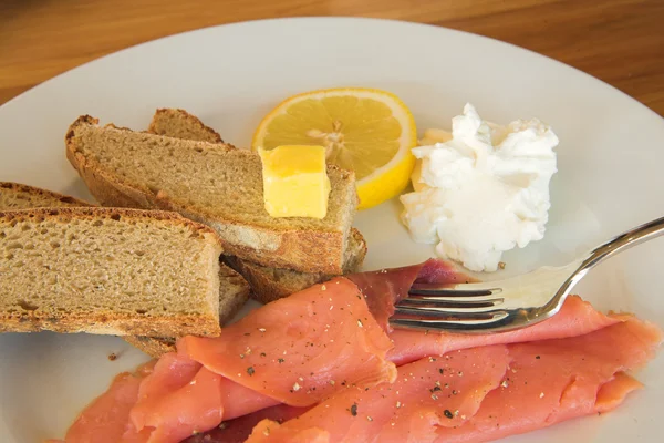 Somon, limon ve krem bir tabak kepekli ekmek — Stok fotoğraf